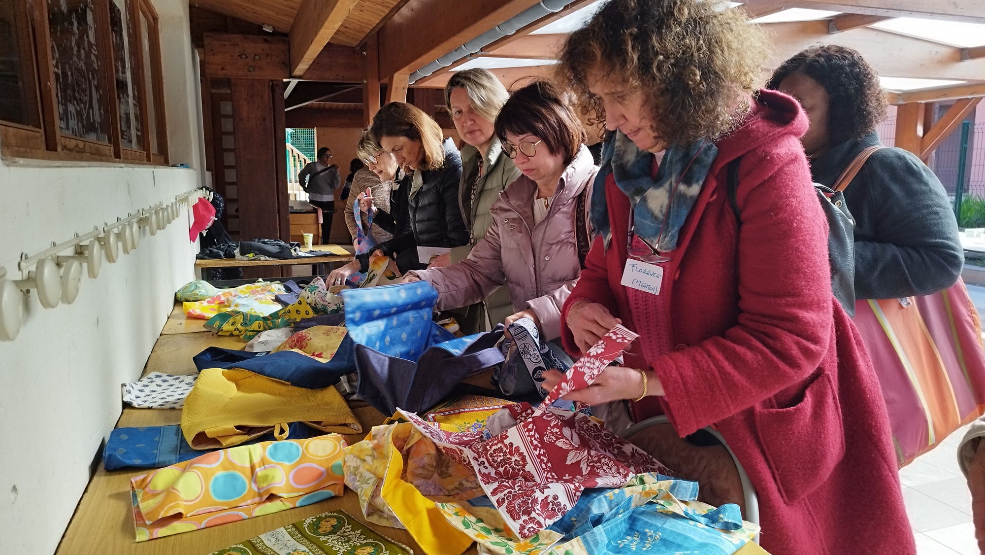 Personnes qui choisissent des sacs exposés sur une table